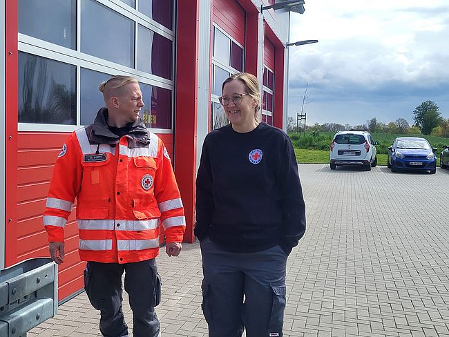 2 Helfer (1 Mann, 1 Frau) stehen vor der Feuerwehr Göhl